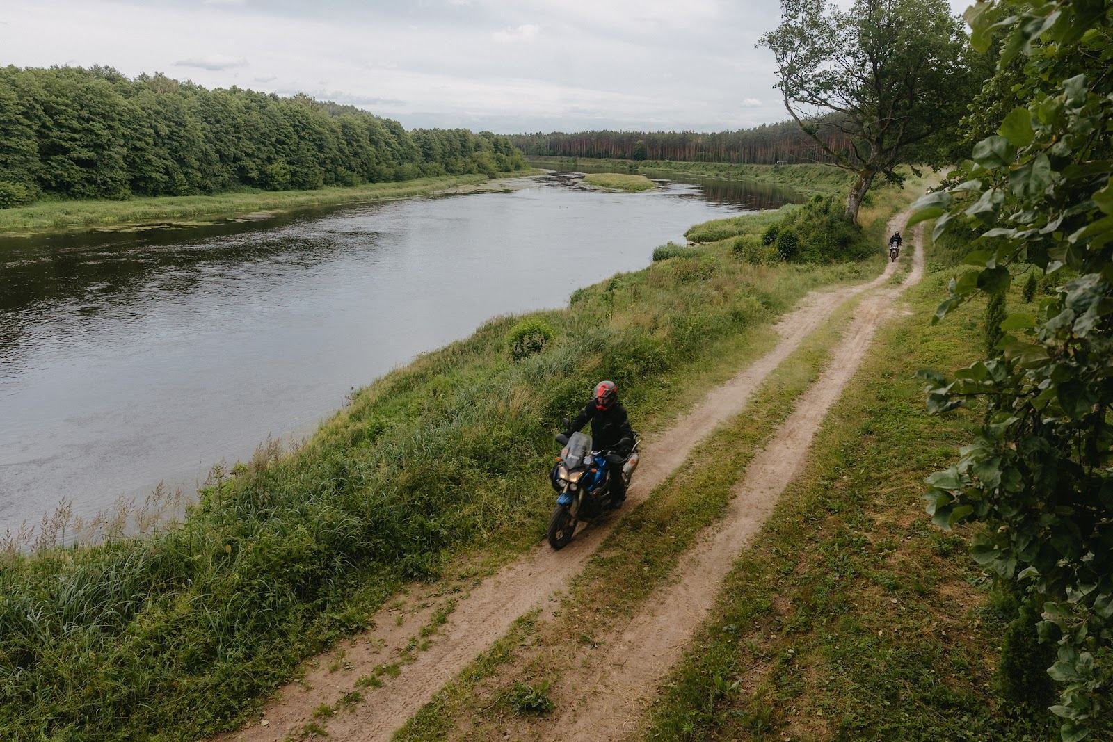 Motociklininkas kelyje palei upę